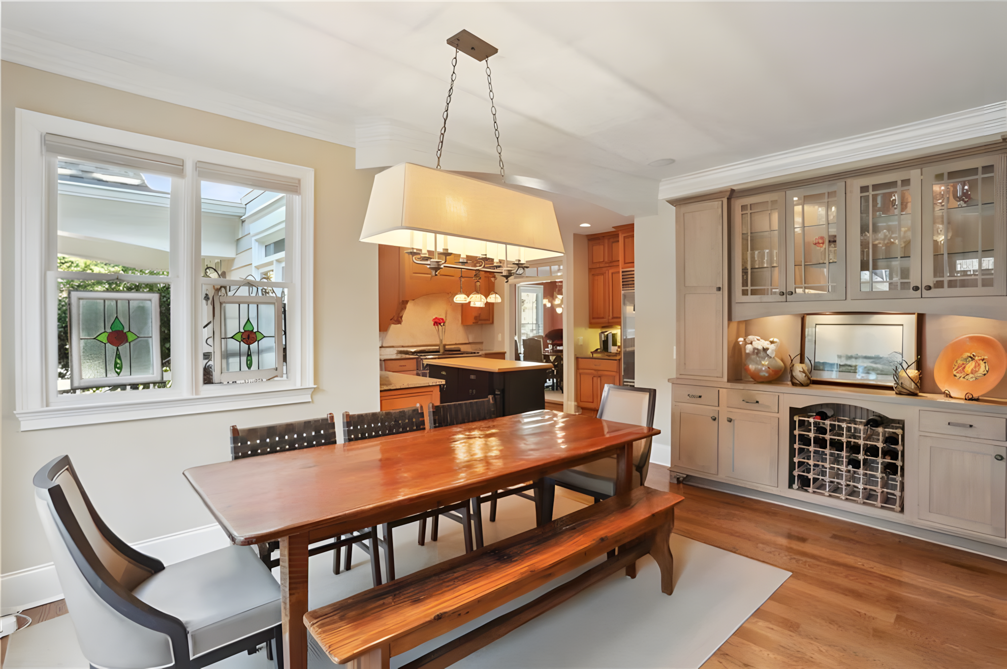 kitchen dining table with kitchen and wine/glassware cabinet in view