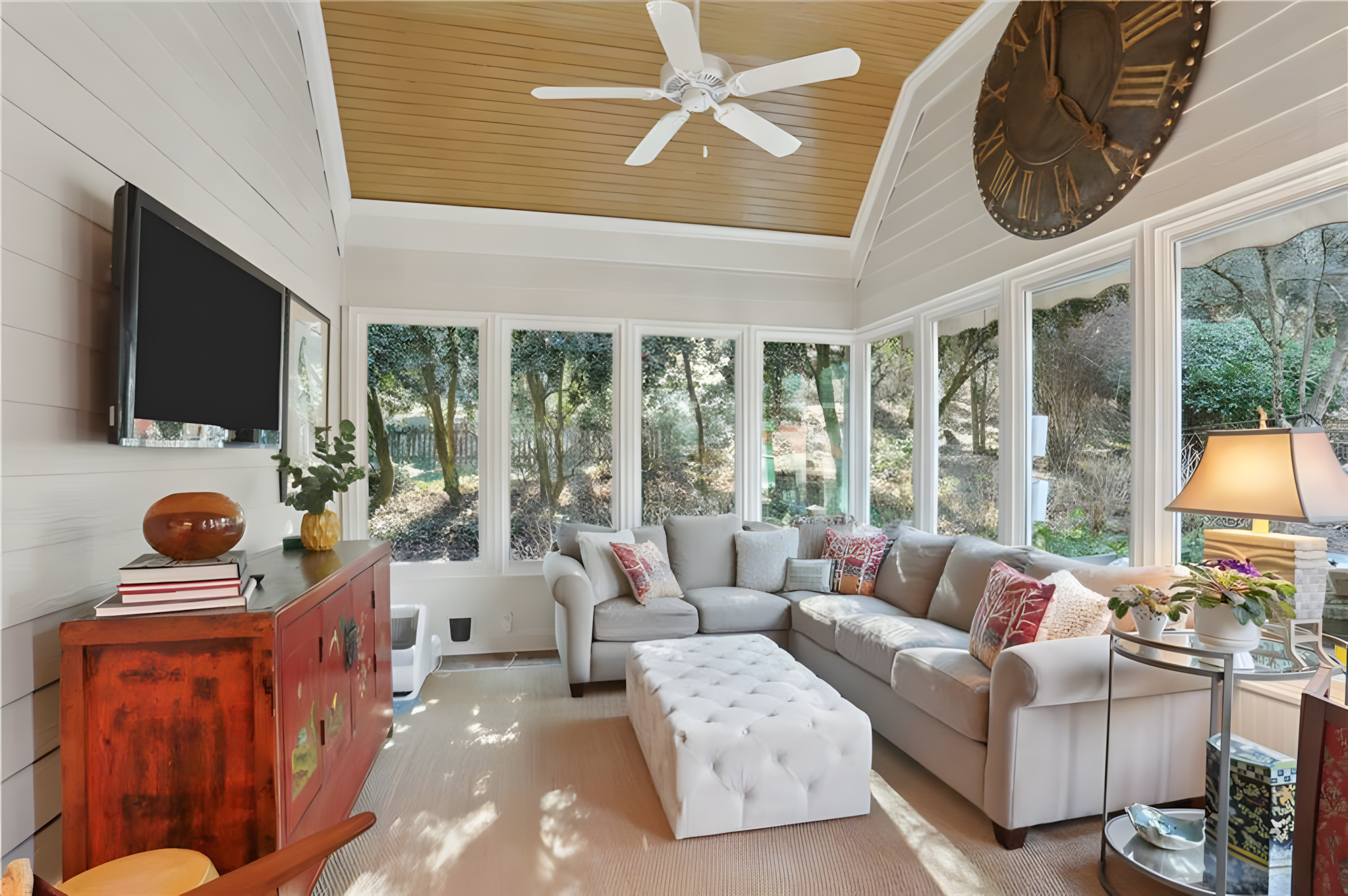 screened porch living area with sectional sofa and tv