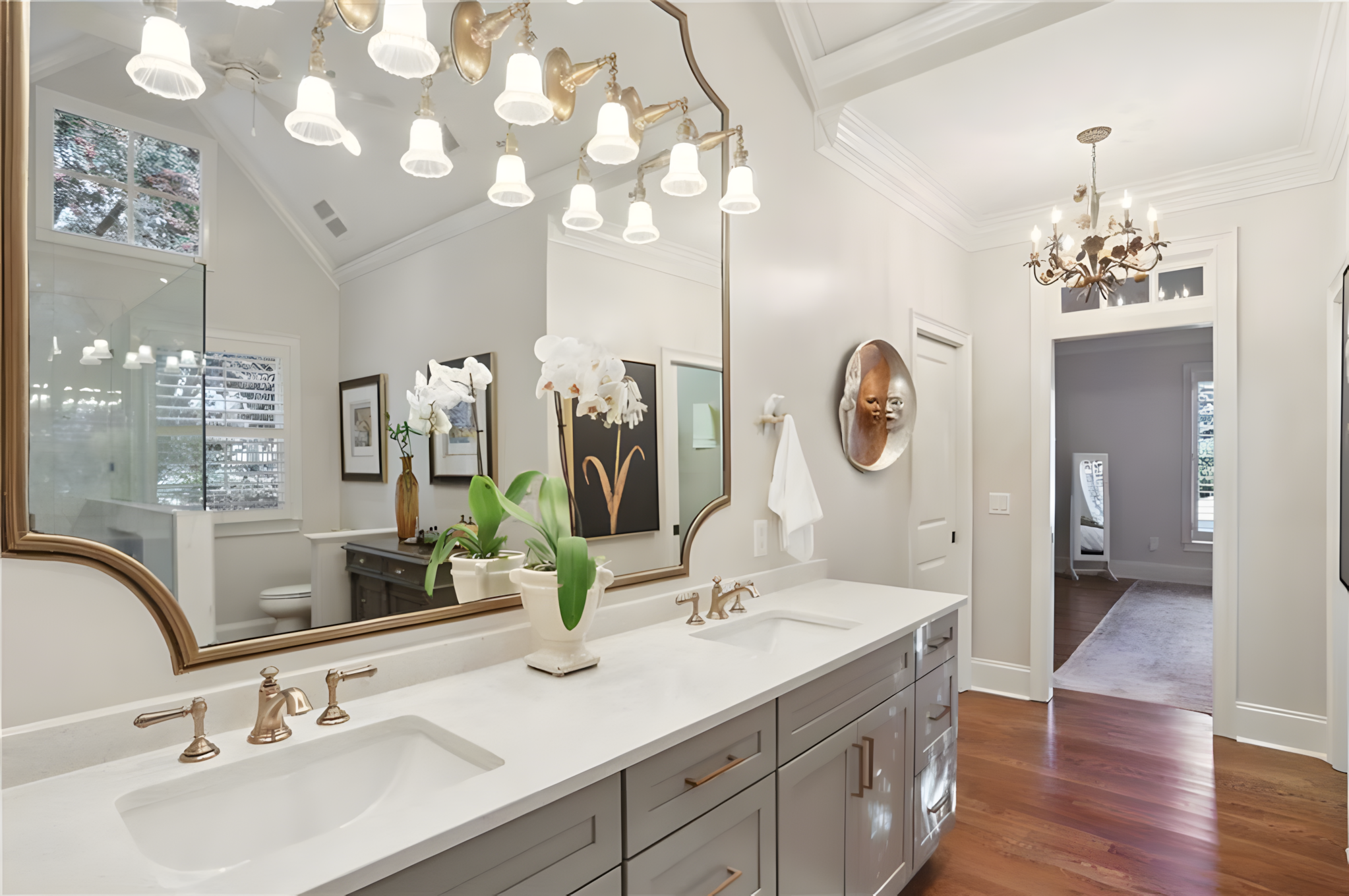 master bathroom double sink with large mirror and row of overhanging sconces