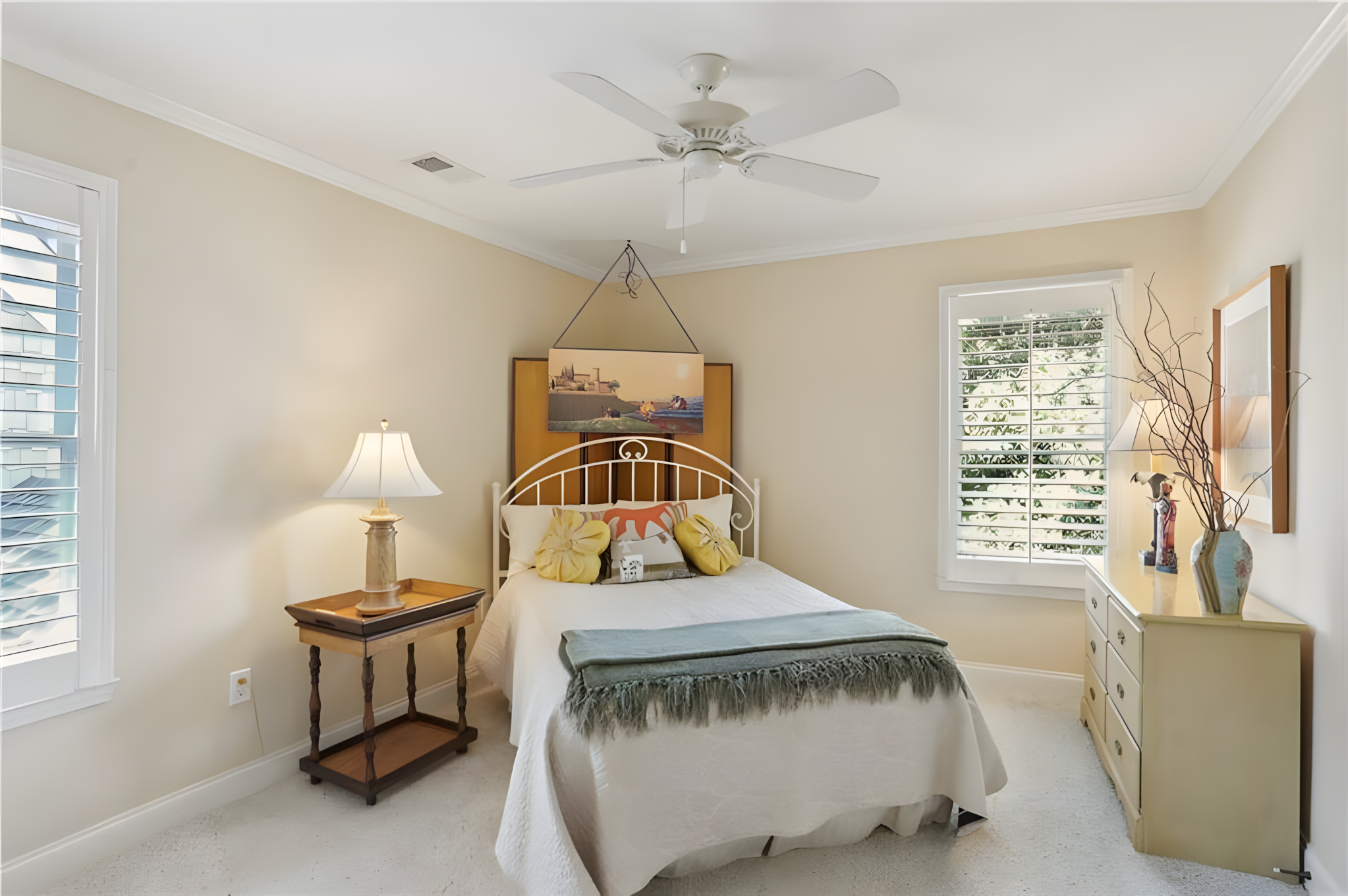 bedroom with diagonal corner bed and hanging painting headboard