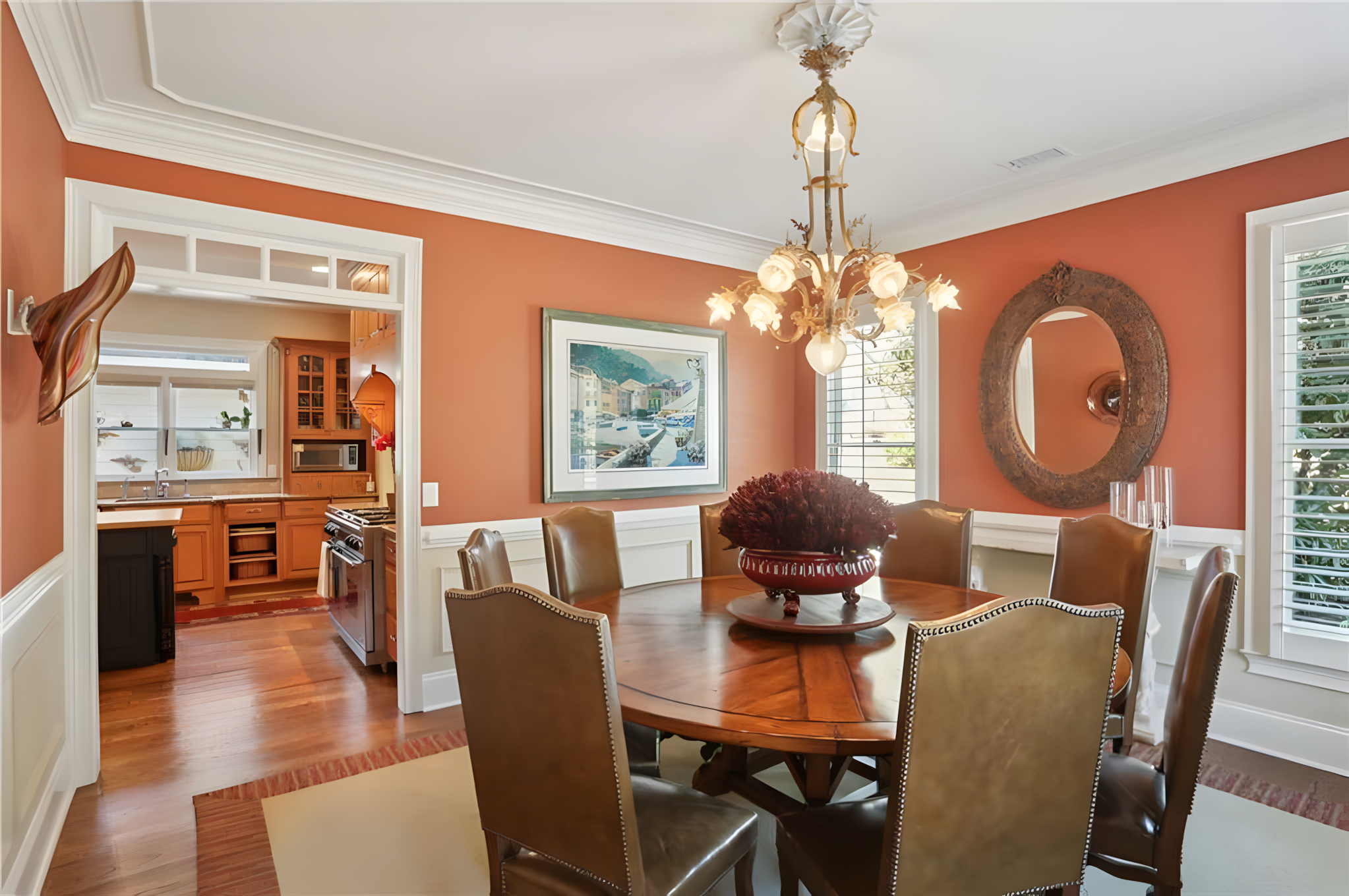 dining room with orange walls, circular table and blooming light fixture