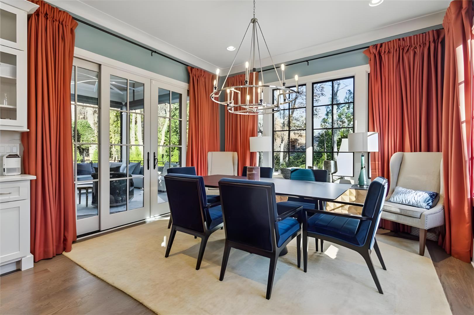 dining room orange curtains, velvet dark blue chairs, patio doors