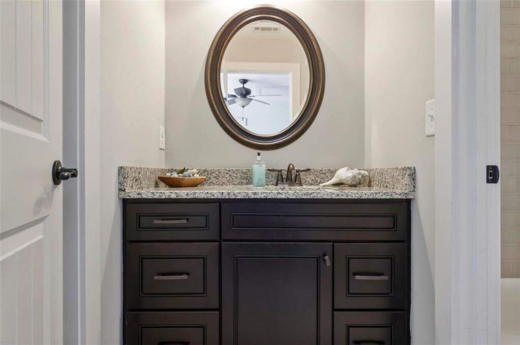 custom residence in historic Marietta district sink brown cabinet and oval mirror